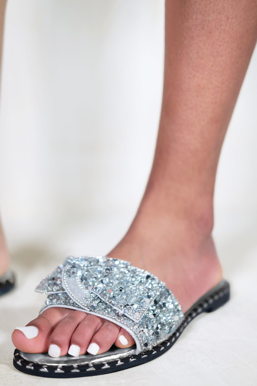 KAMARI DIAMANTE BOW FLAT SLIDERS WITH STUD DETAILS IN MOON SILVER