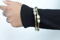 Teardrop Moonstone Brass Cuff - Sleek gold-tone brass cuff with teardrop moonstones in minimalist design.